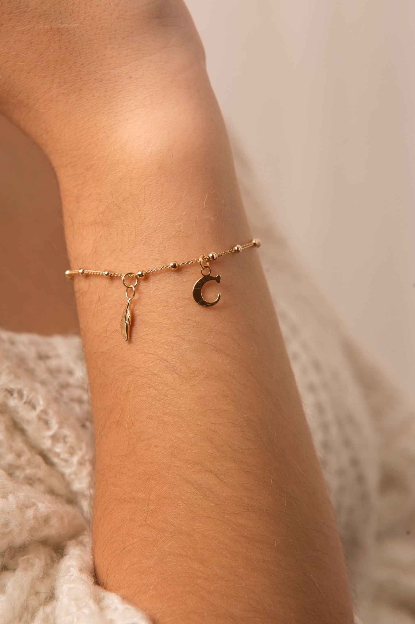 bracelet plaque or avec charms plume
